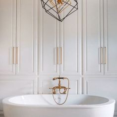 a white bath tub sitting under a chandelier