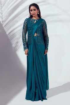 Teal blue pre-draped saree with attached pleated pallu. Comes with embellished jacket and sleeveless blouse.
Component: 3
Pattern: Embellished
Type Of Work: Sequin and Cutdana
Neckline: Round
Sleeve Type: Jacket: Full; Blouse: Sleeveless
Fabric: Satin Silk and Net; Lining: Shantoon
Color: Blue
Other Details: 
Jacket with tassels
Padded blouse
Closure: Blouse: Hook back; Jacket: Button front
Occasion: Destination Wedding - Aza Fashions Drape Sarees, Saree Jackets, Mehndi Outfits, Saree Draping Styles, Drape Saree, Embellished Jacket, Blue Saree, Lehenga Saree, Blouse Sleeveless