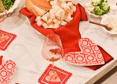 a table topped with plates and bowls filled with food next to wine glasses on top of a table