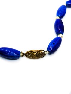 Long blue porcelain and gold beaded vintage necklace. Stunning long blue porcelain beads are accented by small told toned round beads. Vintage box clasp. Good vintage condition with small signs of normal vintage wear. Necklace measures 20 inches long. Vintage Blue Oval Bead Necklace, Vintage Blue Necklace With Oval Beads, Vintage Blue Necklaces With Oval Beads, Vintage Adjustable Blue Necklace, Vintage Blue Single Strand Beaded Necklace, Vintage Blue Single Strand Jewelry, Vintage Blue Single Strand Necklace, Vintage Blue Single Strand Beaded Necklaces, Vintage Blue Necklaces With Polished Beads