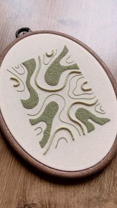 a wooden table topped with a white and green circular object on top of it's surface