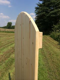 a wooden gate in the middle of a field