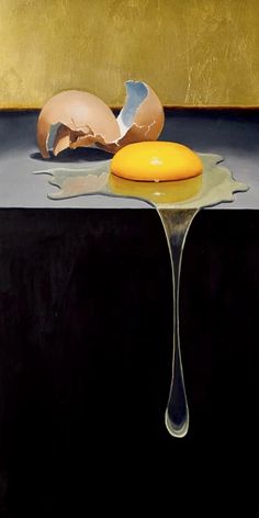 an egg is sitting on top of a table next to a broken egg in the water