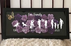 the family silhouettes are made out of purple paper flowers and butterflies on a black frame