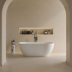 a white bath tub sitting next to a shelf with bottles on it's sides