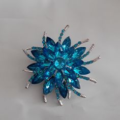 2 1/2 Inch Sparkly Blue Brooch Small Curved Arms With Tiny Ble Stones. Clip On The Back Great Gift Or For Your Self Comes Boxed Blue Crystal Brooch Jewelry, Blue Crystal Jewelry Brooch, Blue Crystal Jewelry With Brooch Detail, Blue Flower-shaped Formal Jewelry, Elegant Blue Brooch For Gift, Elegant Blue Brooch Gift, Blue Crystal Brooches For Gifts, Blue Brooch For Wedding Jewelry, Blue Costume Jewelry Brooch For Wedding