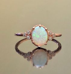 DeKara Designs Collection Our latest design! An Elegant and Lustrous Genuine Pear Shape Australian Opal Surrounded by Beautiful Diamonds in a 14K Rose Gold Halo Setting. Metal- 14K Rose Gold, .583. Stones- Genuine Pear Shape Australian Opal, 8 x 6 MM, 6 Round Diamonds F-G Color VS1-VS2 Clarity 0.18 Carats. Latest of my creations! A Beautifully Hand-crafted Oval Australian Opal Halo Diamond Wedding/Engagement Ring Made in 14K Rose Gold. There is a genuine Australian Opal that is pear shape with b Luxury 14k Rose Gold Oval Jewelry, Luxury Rose Gold Opal Gemstone Ring, 14k Rose Gold Ring With Halo Design, 14k Rose Gold Halo Diamond Ring For Wedding, Wedding Ring In 14k Rose Gold With Halo Setting, 14k Rose Gold Halo Promise Ring, 14k Rose Gold Halo Wedding Jewelry, 14k Rose Gold Halo Design Jewelry Gift, Exquisite Oval Rose Gold Ring