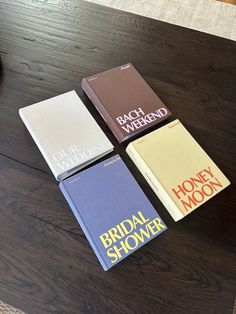 three books sitting on top of a wooden table next to a coffee cup and pen