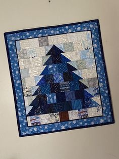 a quilted christmas tree hanging on the wall