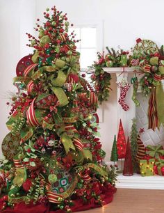 a decorated christmas tree in front of a fireplace