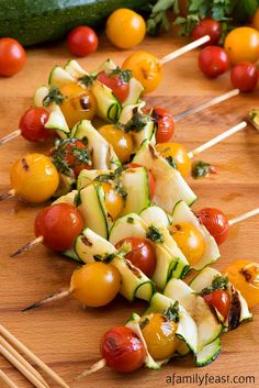 several vegetables on skewers sitting on a wooden table