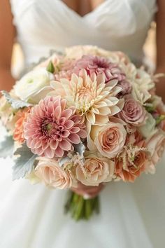 a bride holding a bouquet of pink and white flowers