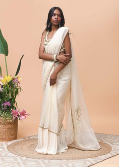 Editor's Note Featuring an ivory sari made in organza fabric crafted with ruffle & trim detail at the edge Note: Blouse worn is for styling purposes only Color: Ivory Fabric: Organza and cotton mesh Occasion: Festive Components: Sari Disclaimer: Product color may slightly vary due to photographic lighting sources or your monitor setting. Care: Dry Clean Only About the Designer Rishi & Vibhuti label combines traditional elements with modern aesthetic uniquely to create chic occasion wear for wome Elegant Cotton Silk Pre-draped Saree With Embroidered Border, White Chanderi Pre-draped Saree For Celebration, White Pre-draped Saree With Sheer Dupatta For Eid, White Organza Pre-draped Saree For Eid, Cream Pre-draped Saree With Sheer Dupatta For Festive Occasions, Transitional White Saree With Sheer Dupatta, White Organza Saree With Traditional Drape, White Organza Saree For Reception, White Pre-draped Cotton Silk Saree With Resham Embroidery