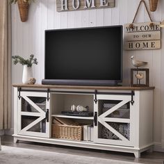 a flat screen tv sitting on top of a wooden entertainment center