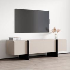 a white and black entertainment center with a large flat screen tv mounted on the wall