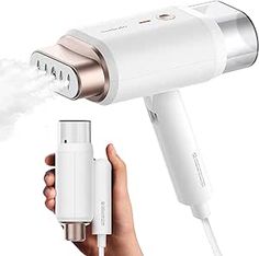 an electric hair dryer being held by someone's hand and spraying it with white liquid