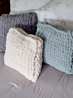 three pillows sitting on top of a bed next to each other in front of a pillow