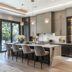 a kitchen with gray cabinets and marble counter tops