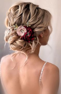 the back of a woman's head wearing a flower in her hair and braid