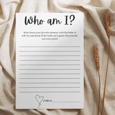 a notepad with the words who am i? written on it next to some dry grass