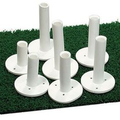 several white plastic poles and bases on green grass