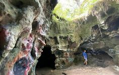 a man standing in the entrance to a cave