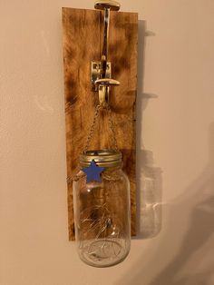 a mason jar hanging on a wall with a chain around it and a blue star