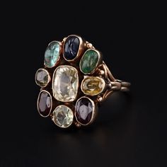 This vintage ring (circa 1960-1970) features assorted gemstones in 14k gold. The gemstones include garnet, zircon, emerald, sapphire, aquamarine, and chrysoberyl. The face of the ring measures 0.9 inches by 0.8 inches wide and is in very good condition with light surface wear. The ring is currently a size 6, but it can be resized free of charge. Materials: 14k gold, chrysoberyl, aquamarine, sapphire, emerald, zircon, garnet. Vintage Multi-stone Ruby Ring In 14k Gold, Multicolor Multi-stone Emerald Oval Ring, Vintage Multi-stone Oval Sapphire Ring, Vintage Oval Multi-stone Sapphire Ring, Heirloom Multi-stone Cluster Ring, Vintage Multi-stone Sapphire Ring, Vintage Multi-stone Ruby Ring Collectible, Vintage Ruby Ring With Multi-stone For Collectors, Vintage Multi-stone Sapphire Ring In 14k Gold