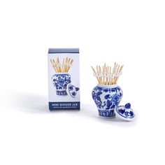 a blue and white vase sitting next to a box with toothbrushes in it