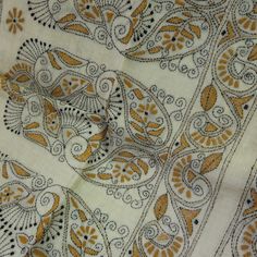 an orange and white paisley design on a fabric with some black dots in the middle