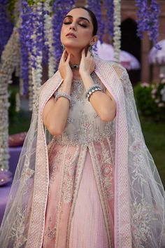 a woman wearing a pink and white outfit with purple flowers hanging from it's ceiling