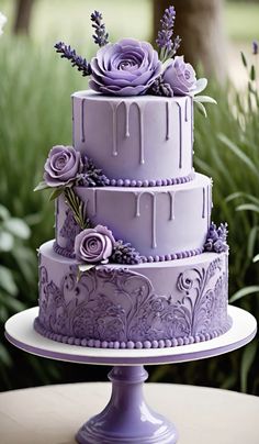 a three tiered cake with purple icing and flowers