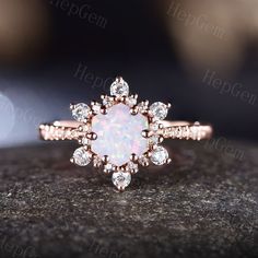 an opal and diamond ring on top of a rock