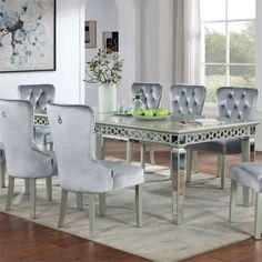 a dining room table with six chairs and a vase on the floor in front of it