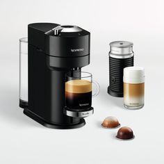 an espresso machine with two cups next to it