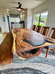 a dining room table made out of wood and black eperfecting on the top