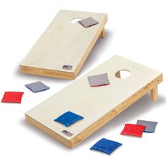 two cornhole boards with blue and red cloths on the floor next to each other