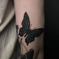 a black and white butterfly tattoo on the arm