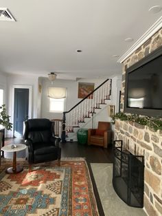 a living room filled with furniture and a flat screen tv mounted on the wall next to a fire place