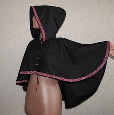 This fantasy cape (hooded short cloak) is made from black cotton, decorated with trim, and has lacing on the front. Light and breathable material makes such a cape perfect in protecting your head from the sun during sunny weather and comfortable for indoor events. The capelet is wide so it will not hinder your movements during LARP, renfaire or other fantasy events.  Such a cape can be worn both by man and woman Size (picture  #8 shows all the measurements): Length from the front: 11 inches (28 Light Armour, Black Capelet, Fantasy Cape, Short Cloak, Hooded Capelet, Character Prompts, Indoor Event, Hooded Cape, Sunny Weather