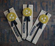 three yellow and black flower hair clips on top of brown paper with white flowers in the center