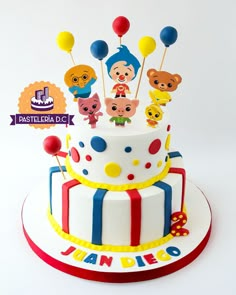 a multi layer cake with cartoon characters on top and balloons in the air above it