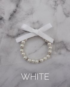 This item is FINAL SALE. No exchange or refund. Elegant elastic ivory pearls bracelet with beads and clear rhinestones with satin ribbon bow. Available is Silver and Gold beads in between pearls.This listing is only for 1 bracelet. Great for bride, bridesmaids, flower girls gift to wear on the wedding day.Bracelet is measured to approximately 7 - 8 inches, however, it can stretch to match wrist larger due to the the elastic. White Pearl Beaded Bracelet For Wedding, White Pearl Embellished Bracelets For Party, White Pearl-embellished Bracelet For Party, White Pearl Embellished Bracelets For Wedding, White Pearl Beaded Bracelets, Elegant Pearl Stretch Bracelet For Wedding, Adjustable Stretch Bracelet For Wedding, Formal White Pearl Embellished Bracelets, Formal White Pearl Bracelets