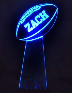 the illuminated football sign is lit up in the dark with blue light and black background