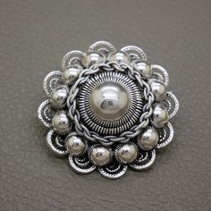 a silver brooch sitting on top of a table