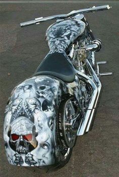 a custom painted motorcycle parked in a parking lot with skulls on the front and sides