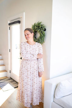 a woman standing in front of a door wearing a dress