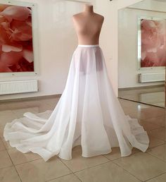 a white wedding dress on display in a room