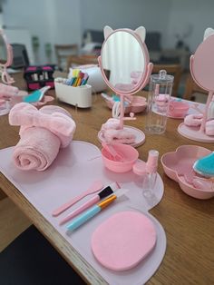 a wooden table topped with lots of pink items and decorating utensils on top of it