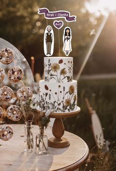 a wedding cake sitting on top of a wooden table